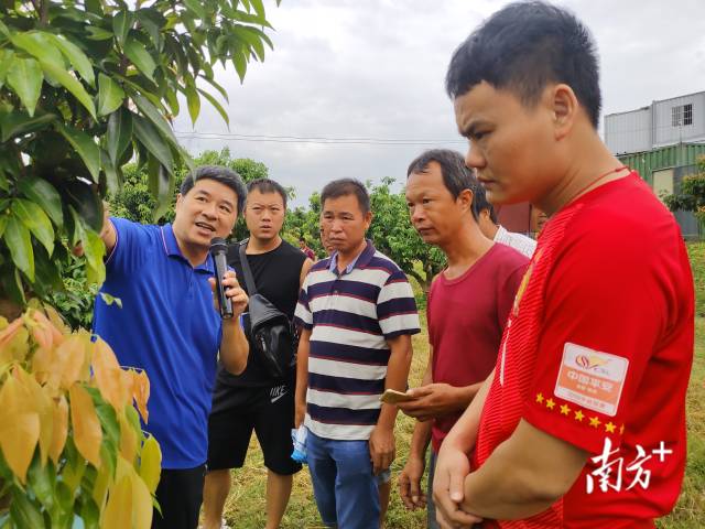 连国荣(左一)向农户传授种植经验。